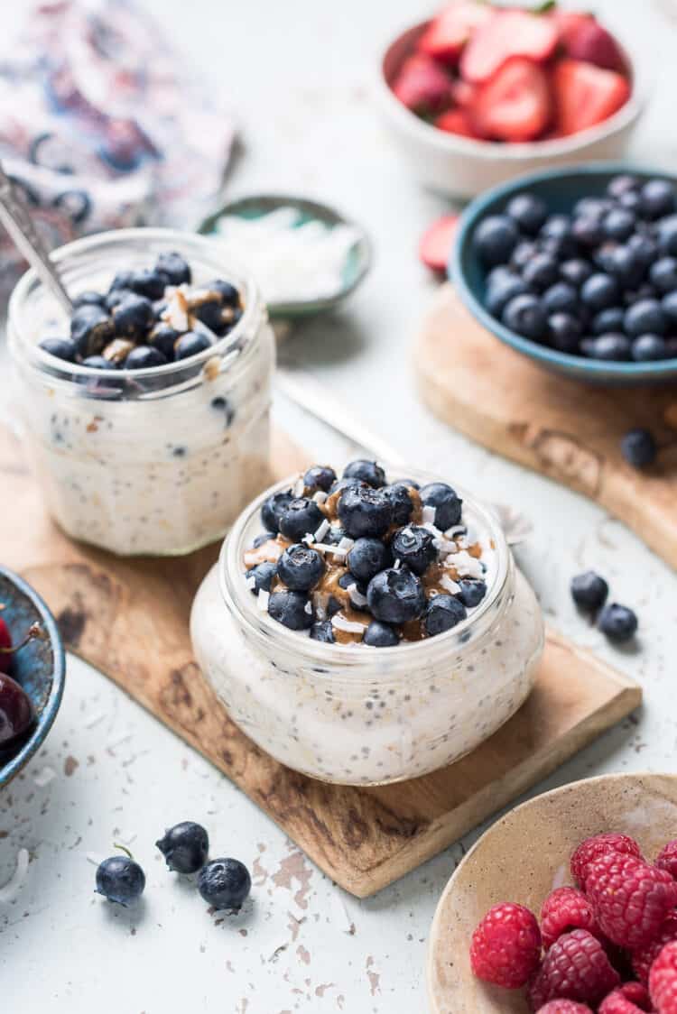 Blueberry Muffin Overnight Oats with fresh blueberries, almond butter and coconut flakes in a jar.