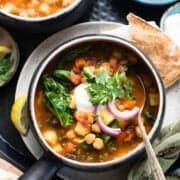 Chana Masala Soup in a soup bowl topped with cilantro, red onion, and greek yogurt.