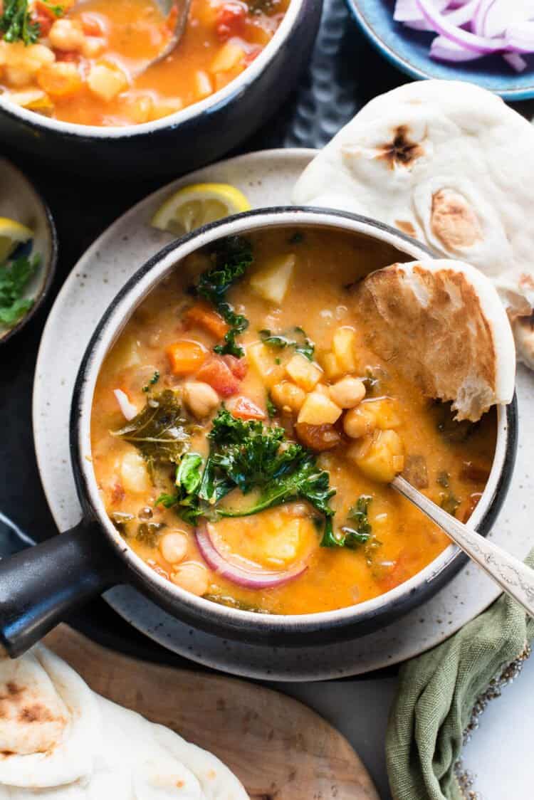 Chana Masala Soup with naan in a bowl.