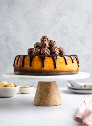Nutella Ganache Covered Cheesecake on a cake stand.