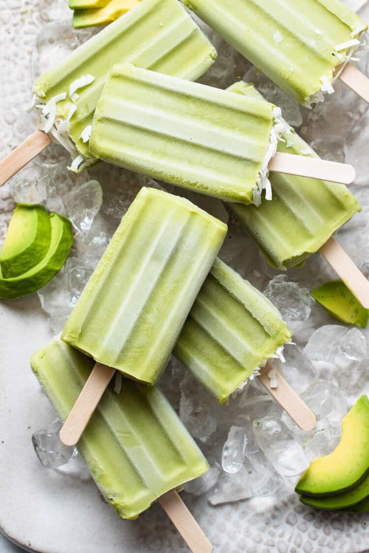Avocado Popsicles on ice on a tray.