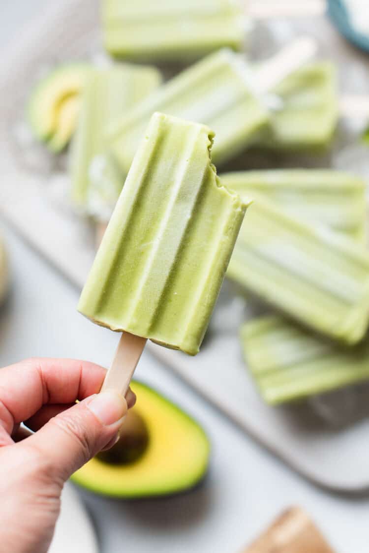 An avocado popsicle with a bite.