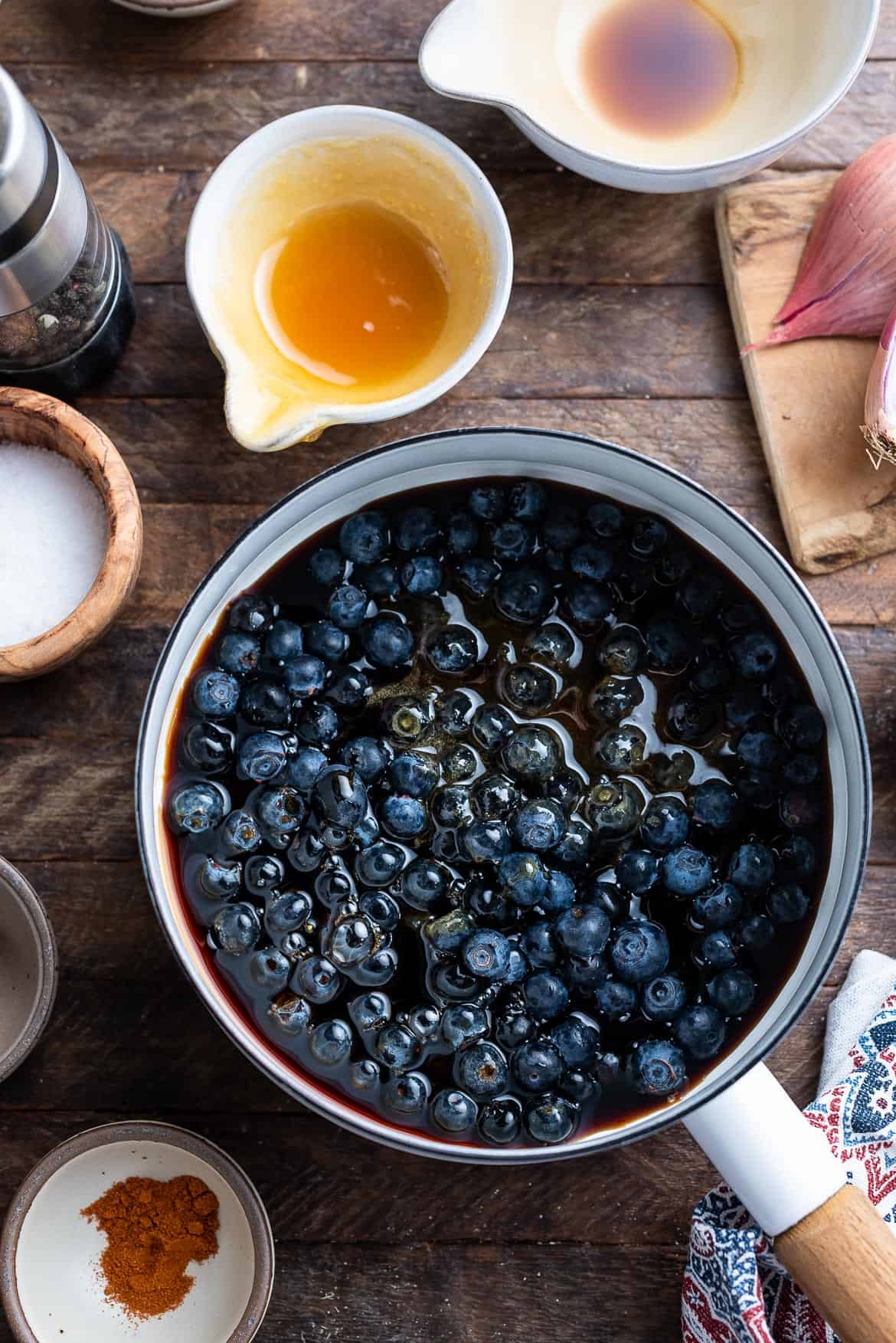 Making Blueberry Balsamic Barbecue Sauce in a white sauce pan.