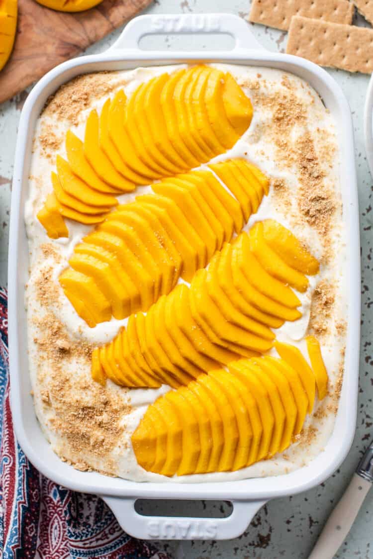 An assembled mango float in a white baking dish.