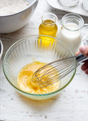 Whipping eggs in a ribbed glass bowl.