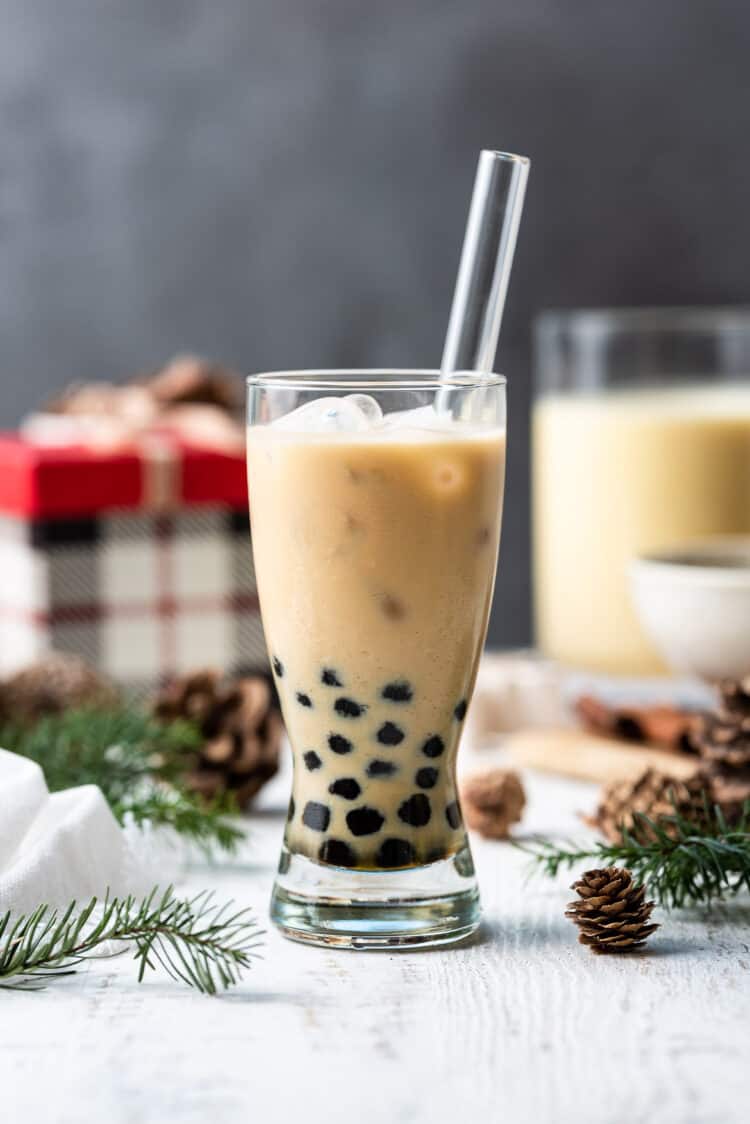 Eggnog Milk Tea Boba in a glass with a straw.