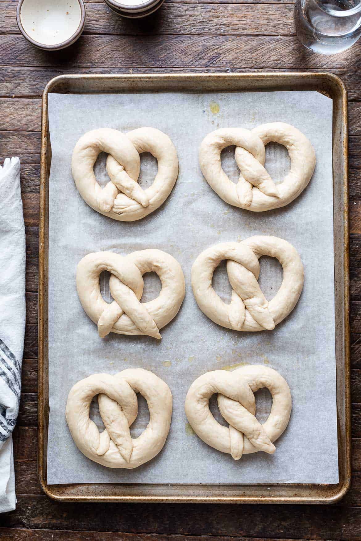 Shaped Bavarian pretzels on a bakng sheet.