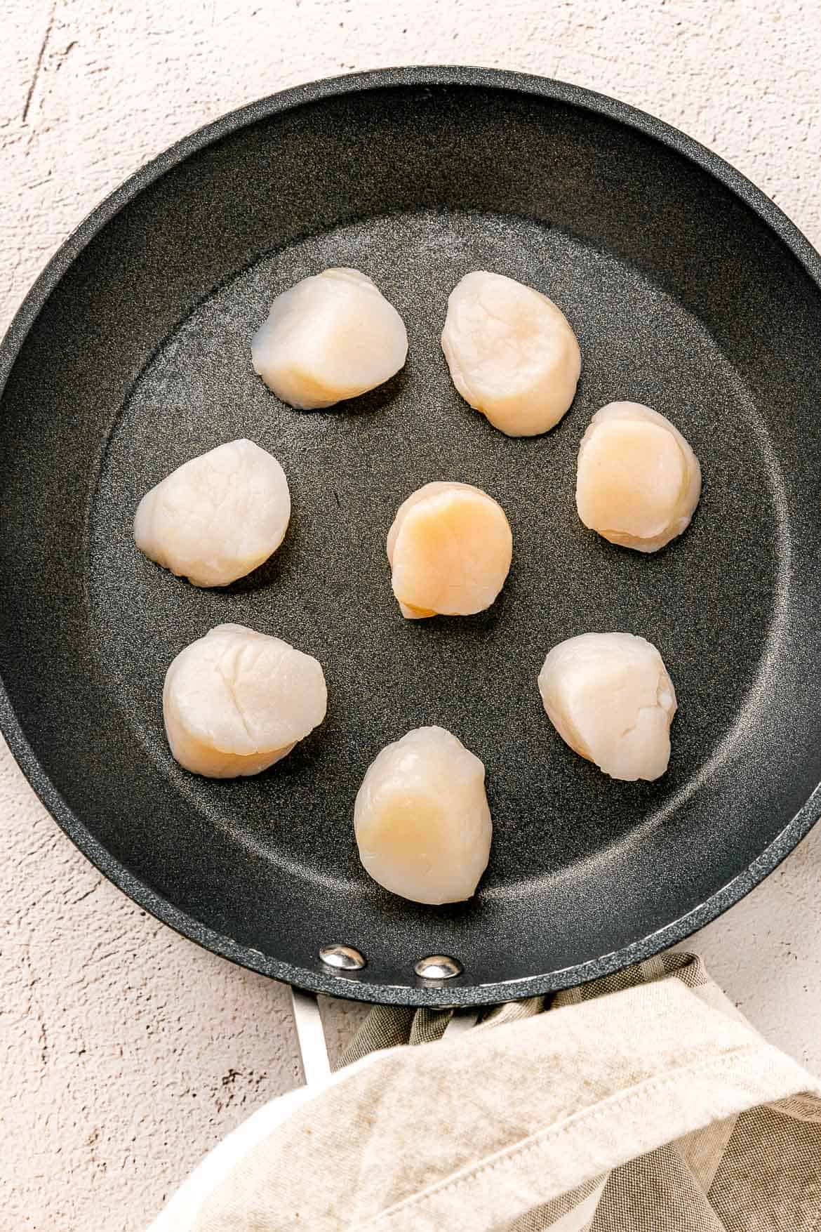 Scallops in a non stick pan.