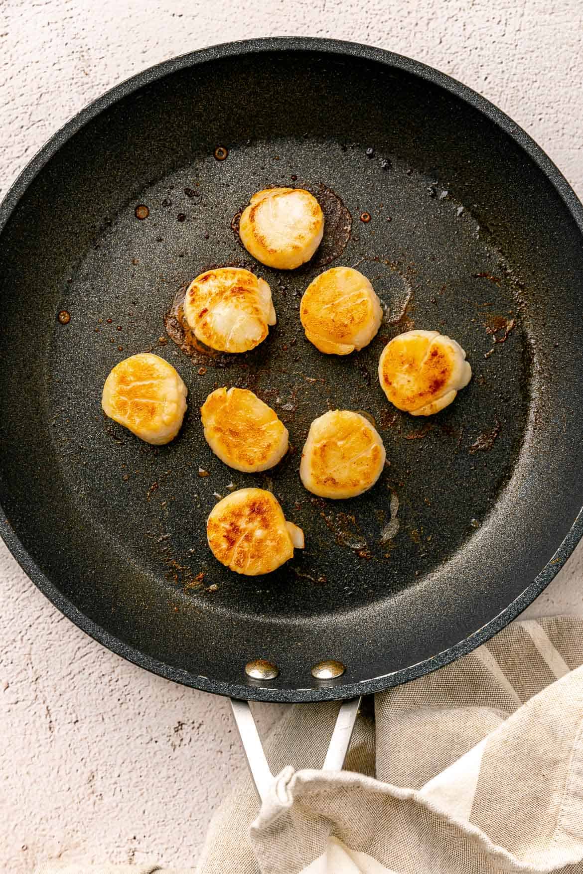 Seared scallops in a non-stick pan.
