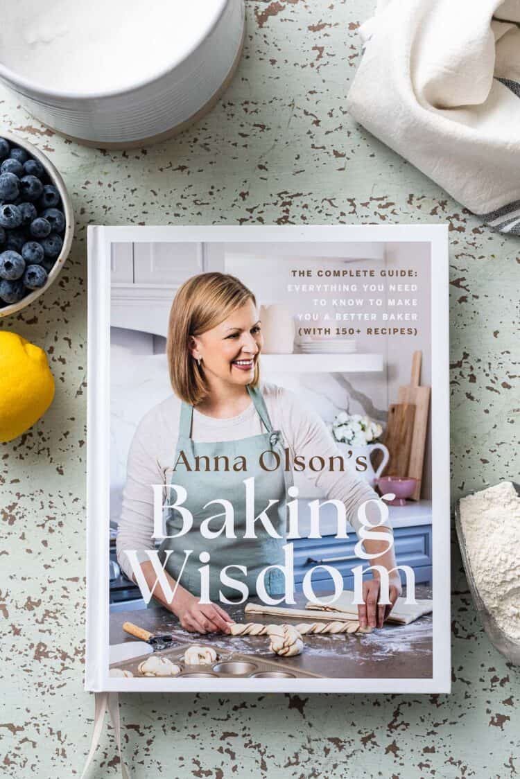 Anna Olson's Baking Wisdom cookbook on a table.
