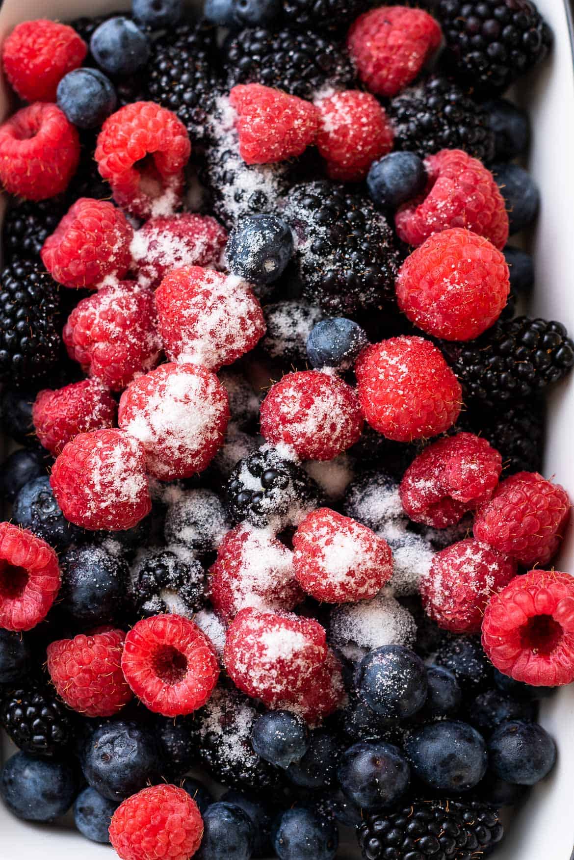 Raspberries, blueberries, blackberries, and sugar for compote.