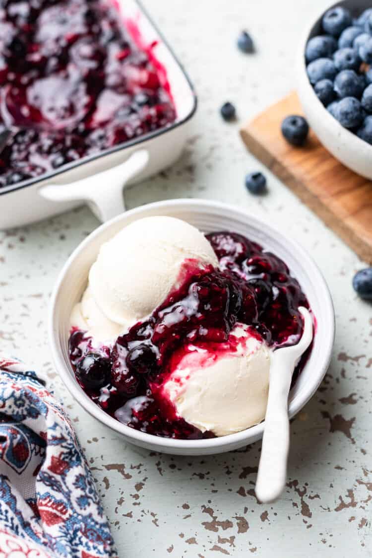 Mixed berry compote drizzled over vanilla ice cream.