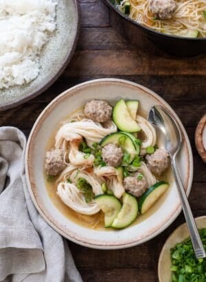 Filipino Meatball Noodle Soup (Misua Bola Bola) in a bowl, with rice eon the side.