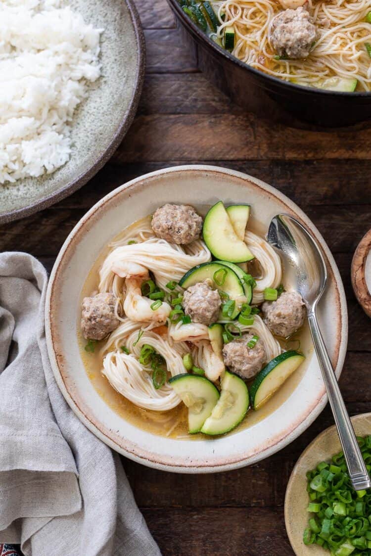 Filipino Meatball Noodle Soup (Misua Bola Bola) in a bowl, with rice eon the side.