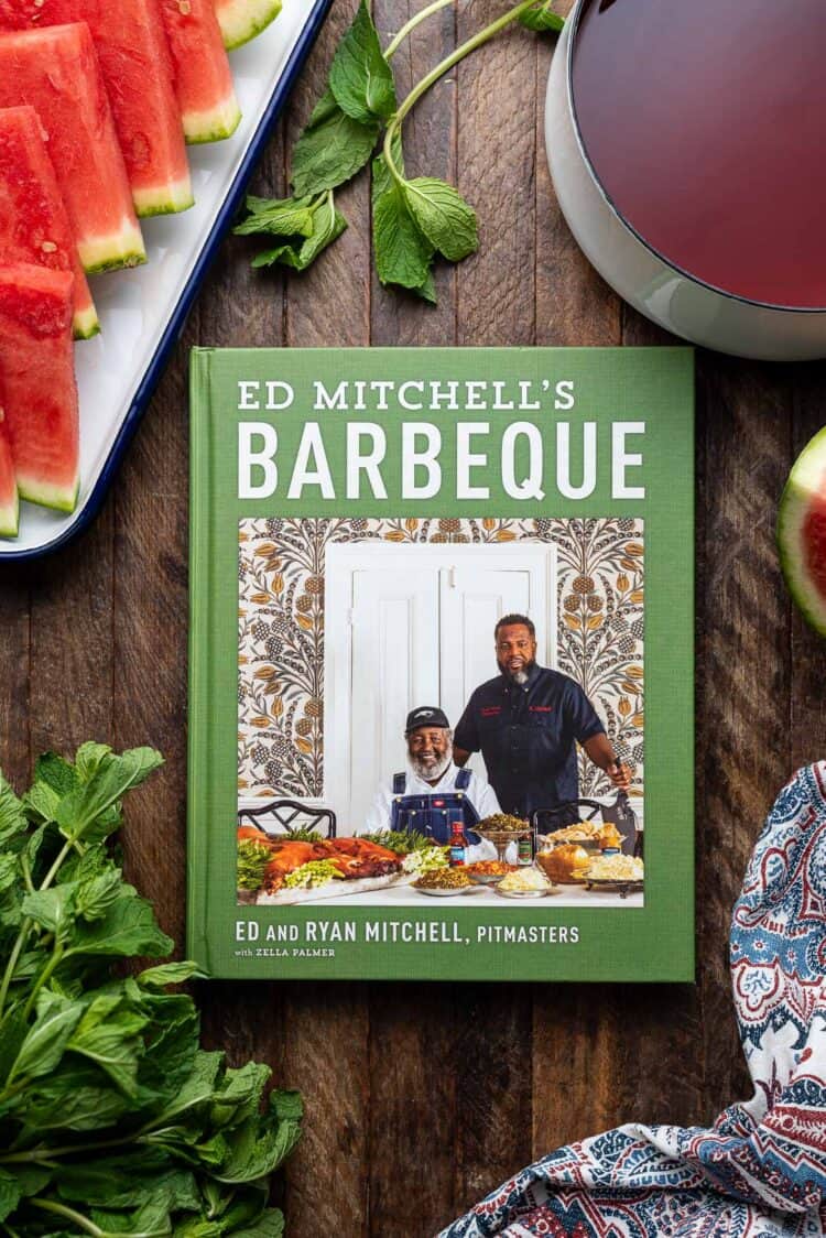 The cookbook Ed Mitchell's Barbeque on a wooden table.