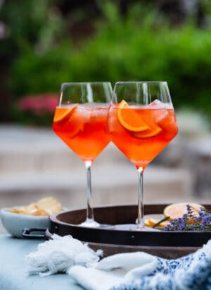 Aperol Spritz in wine glasses garnished with orange slices.