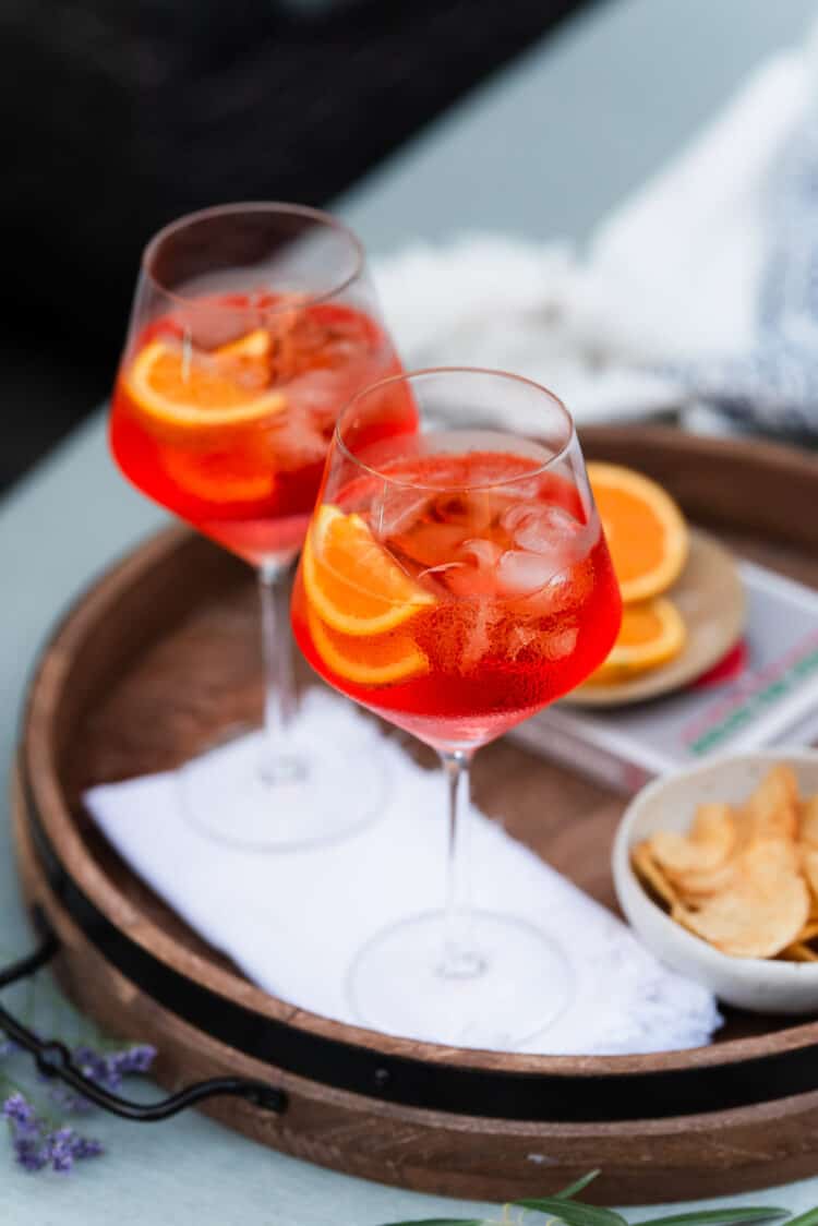 Aperol Spritz in wine glasses garnished with orange slices.
