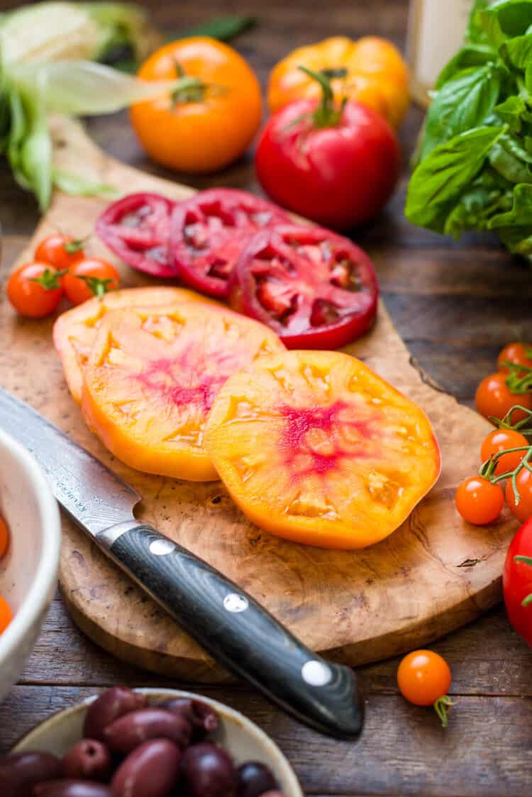 Heirloom tomatoes sliced on a board.
