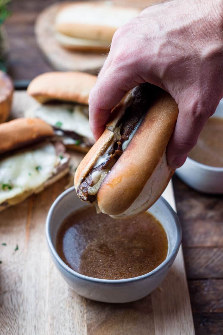 Dipping a French Dip Sandwich into au jus broth.