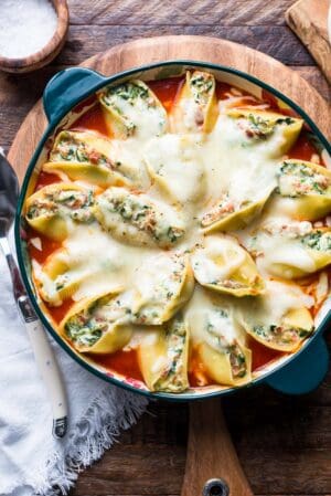 Stuffed shells with prosciutto and spinach in a dish.