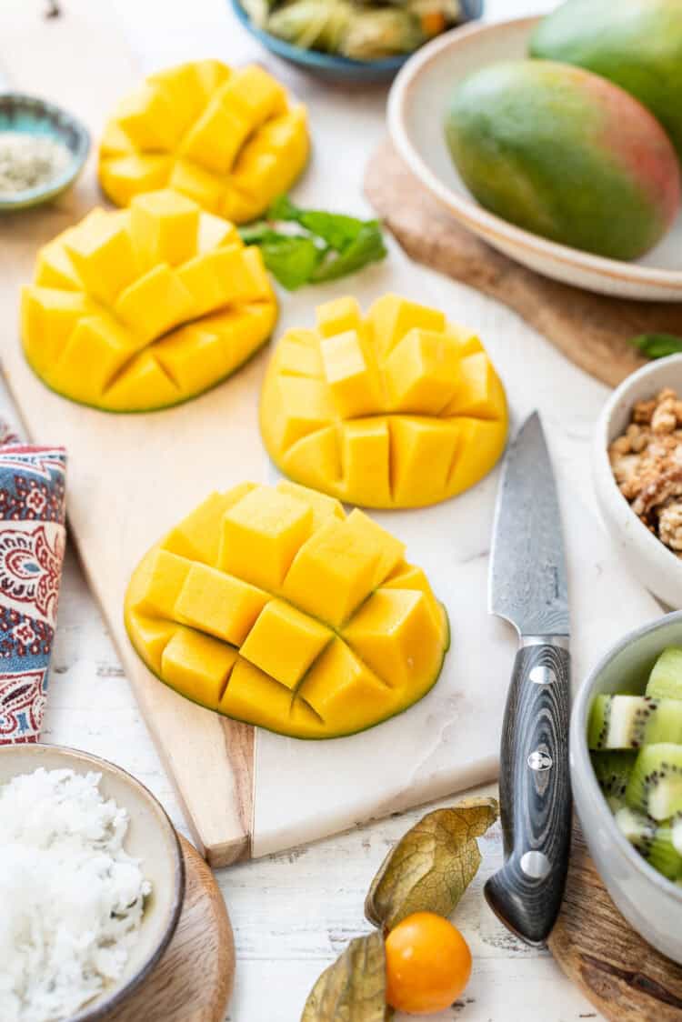 Mangoes scored and sliced on a cutting table.