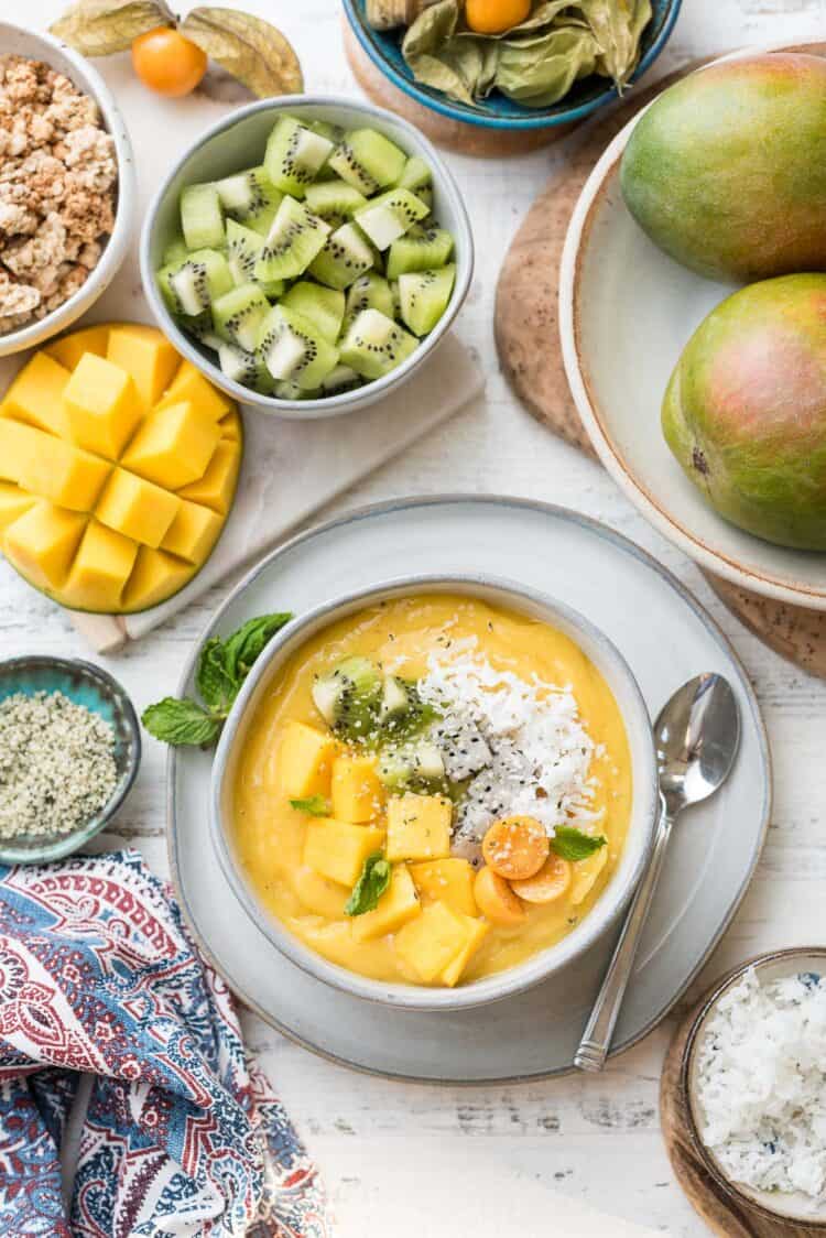 Tropical Mango Smoothie Bowl with Mango topped with fresh mango, golden berries, and shredded coconut.