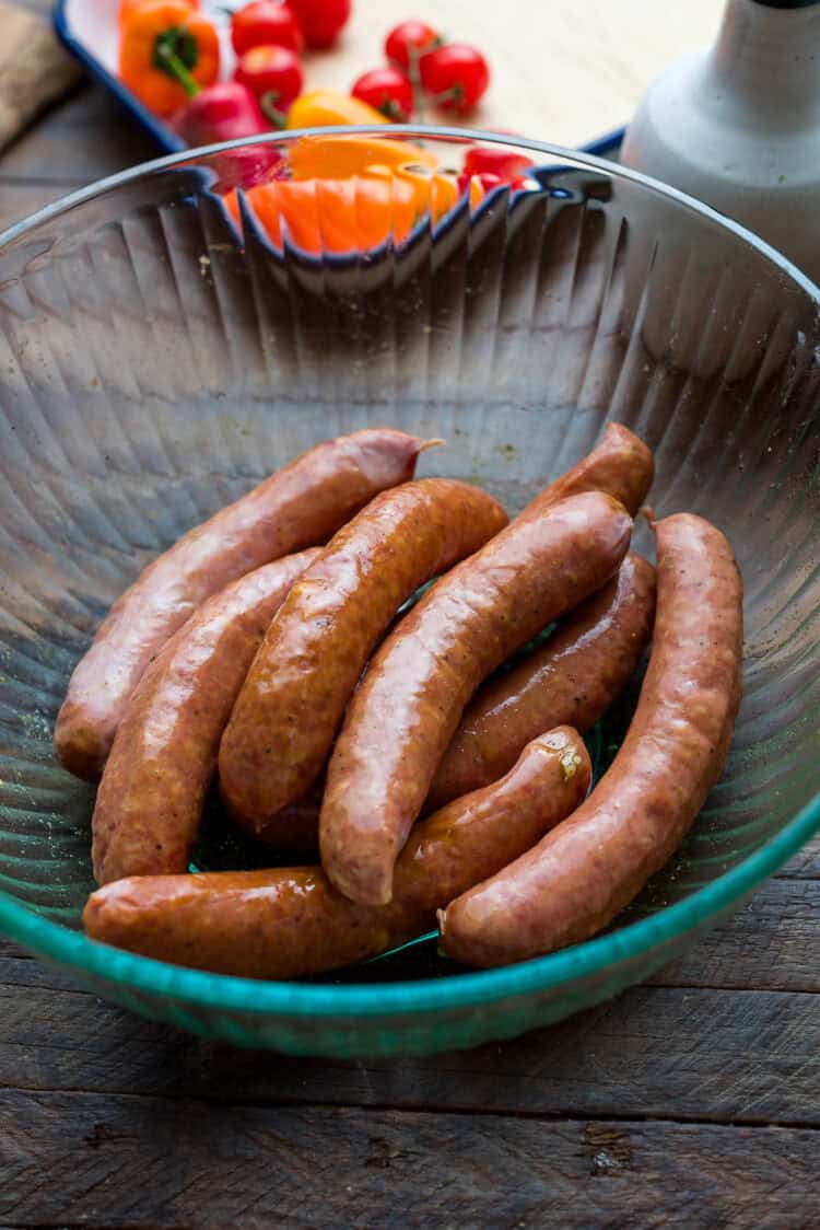 Chicken sausage for sheet pan sausage recipe in a glass bowl.