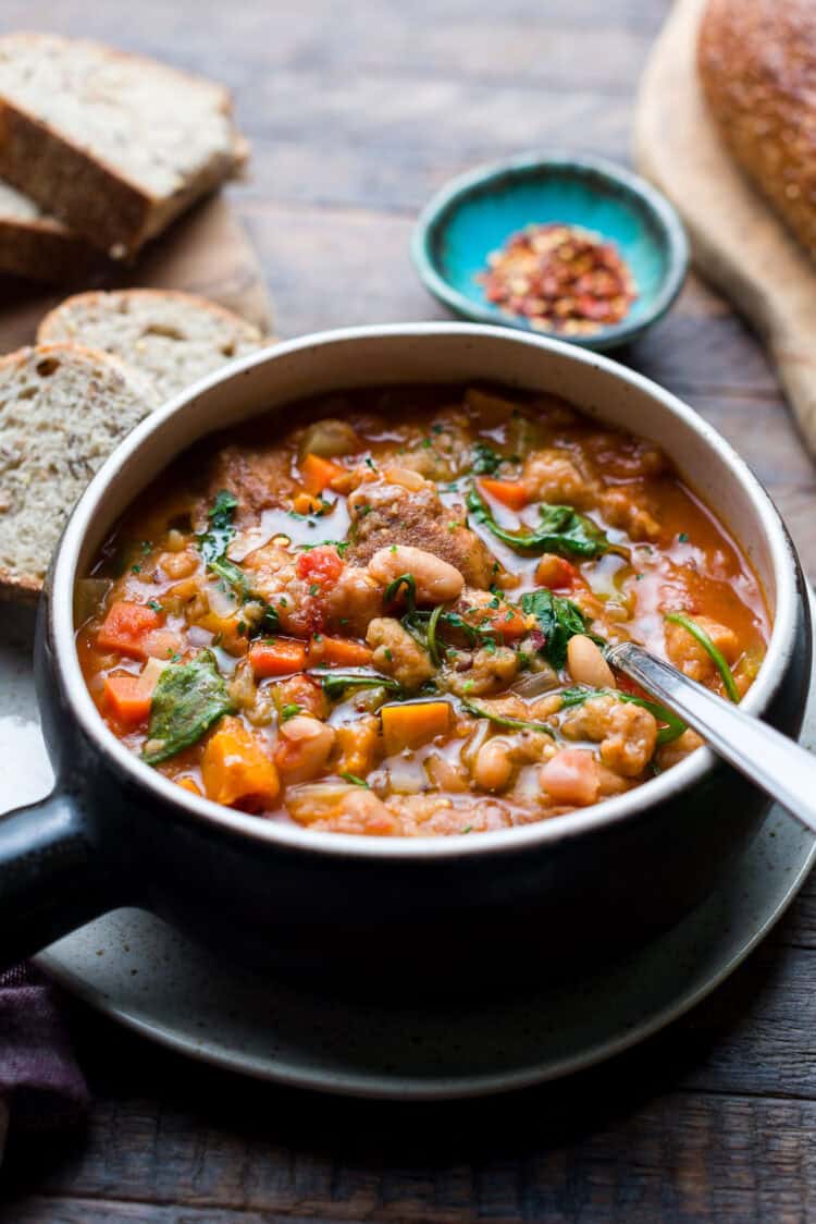 Ribollita (Tuscan-style Bread Soup) in a bowl, with a bread on the side.