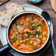 Ribollita (Tuscan-style Bread Soup) served in a soup bowl, with a side of bread.