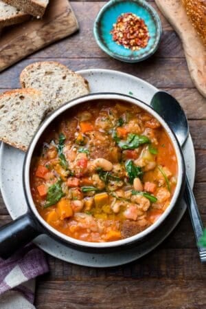 Ribollita (Tuscan-style Bread Soup) served in a soup bowl, with a side of bread.