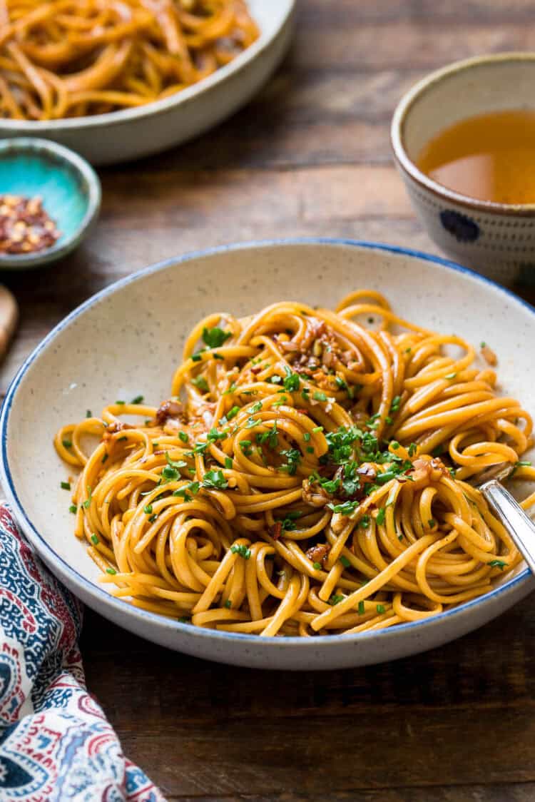 Savory Miso-Butter Garlic Noodles in a blue-rimmed pasta bowl.