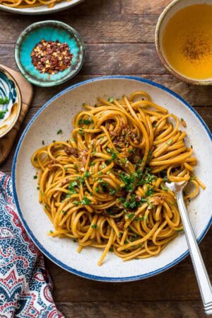 Savory Miso-Butter Garlic Noodles in a blue-rimmed pasta bowl.