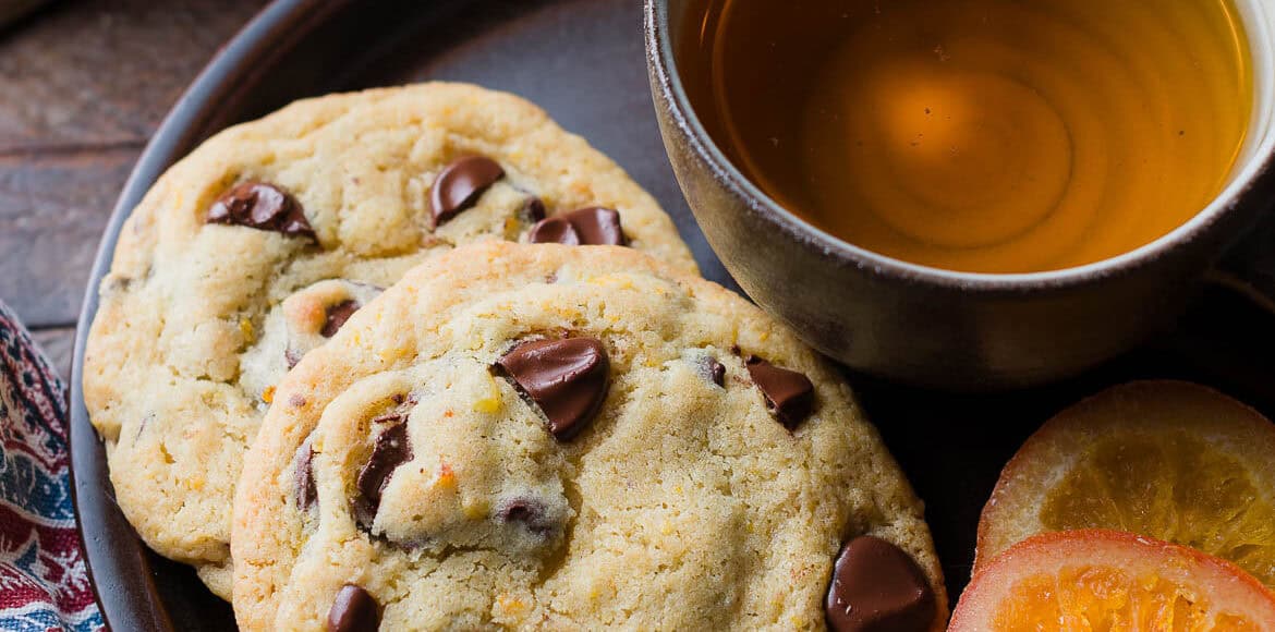 Dark Chocolate Orange Cookies on a plate with a. cup of tea.