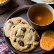 Dark Chocolate Orange Cookies on a plate with a. cup of tea.