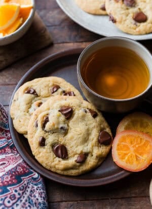 Dark Chocolate Orange Cookies on a plate with a. cup of tea.