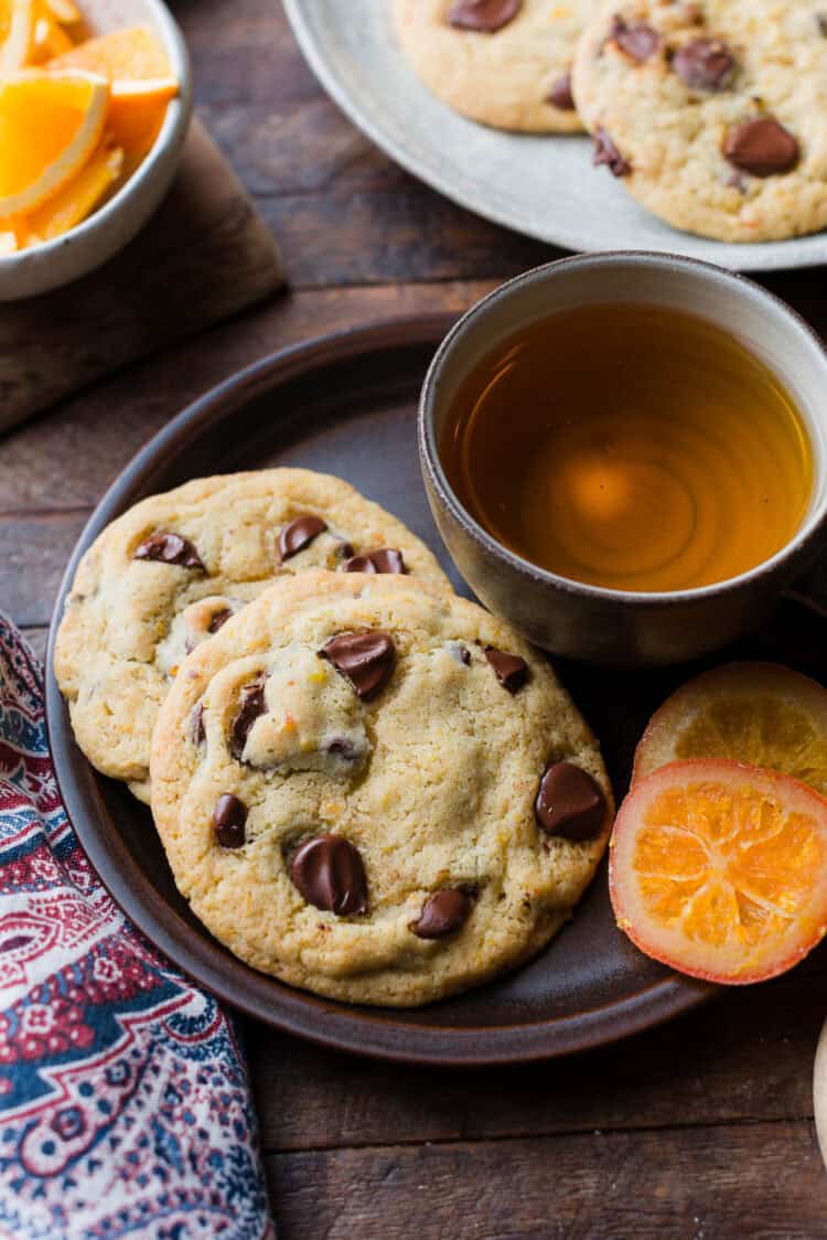 Dark Chocolate Orange Cookies on a plate with a. cup of tea.