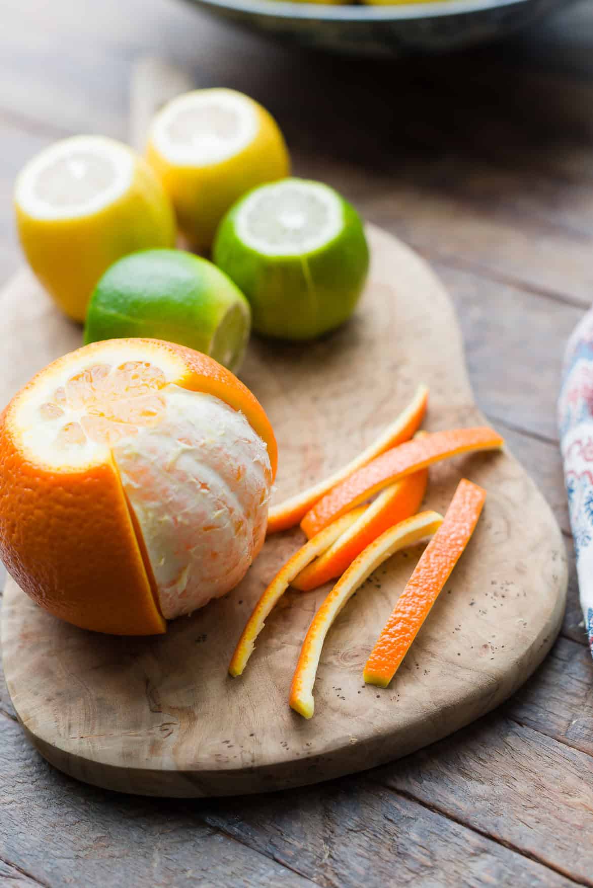 Peeling and slicing orange to make candied citrus peel.