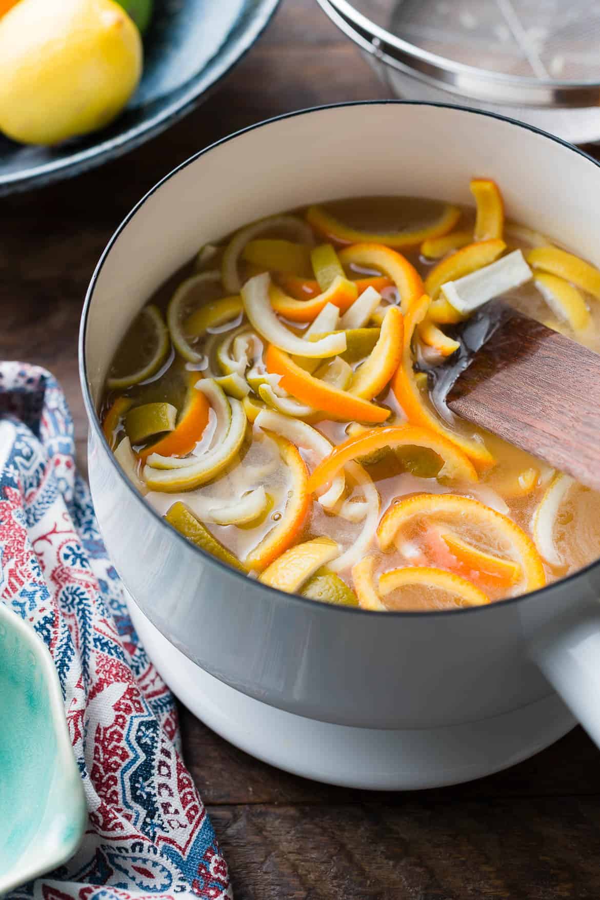 Simmering citrus peel in sugar syrup.