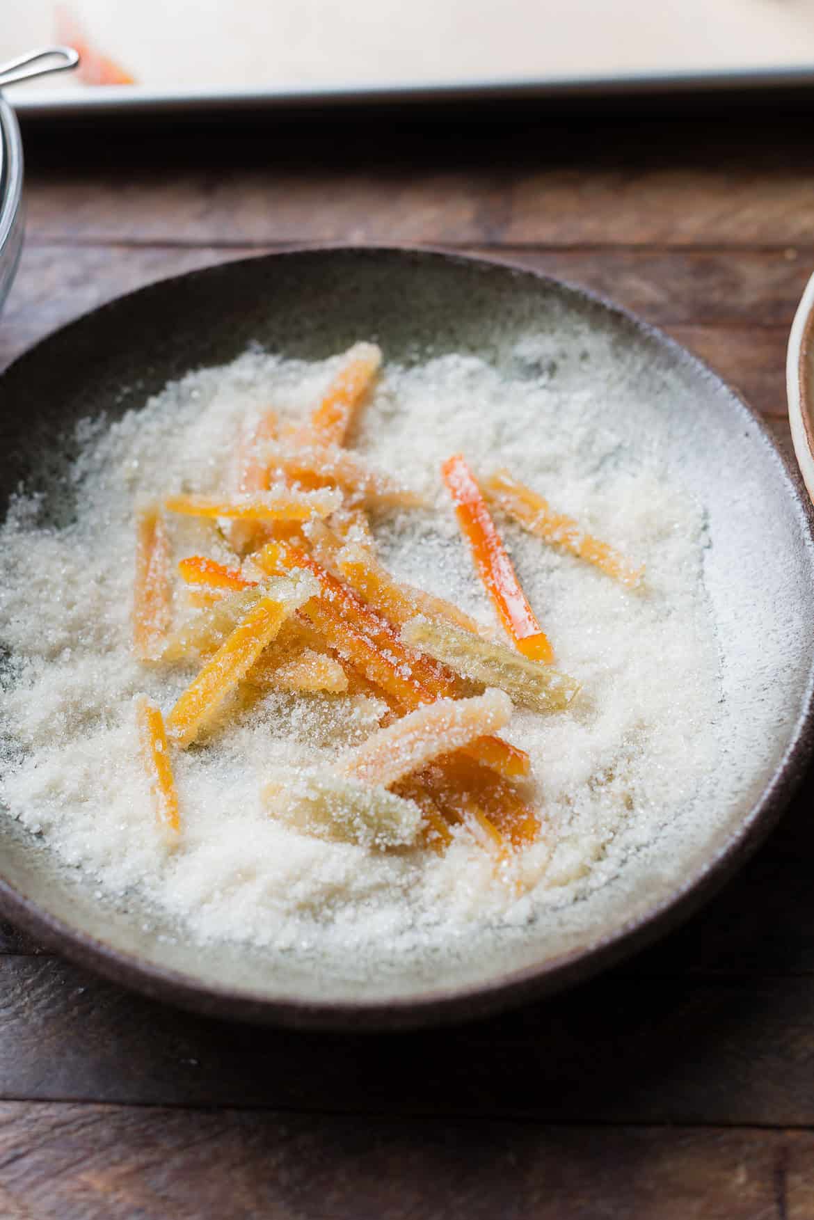 Tossing candied citrus peel in sugar.