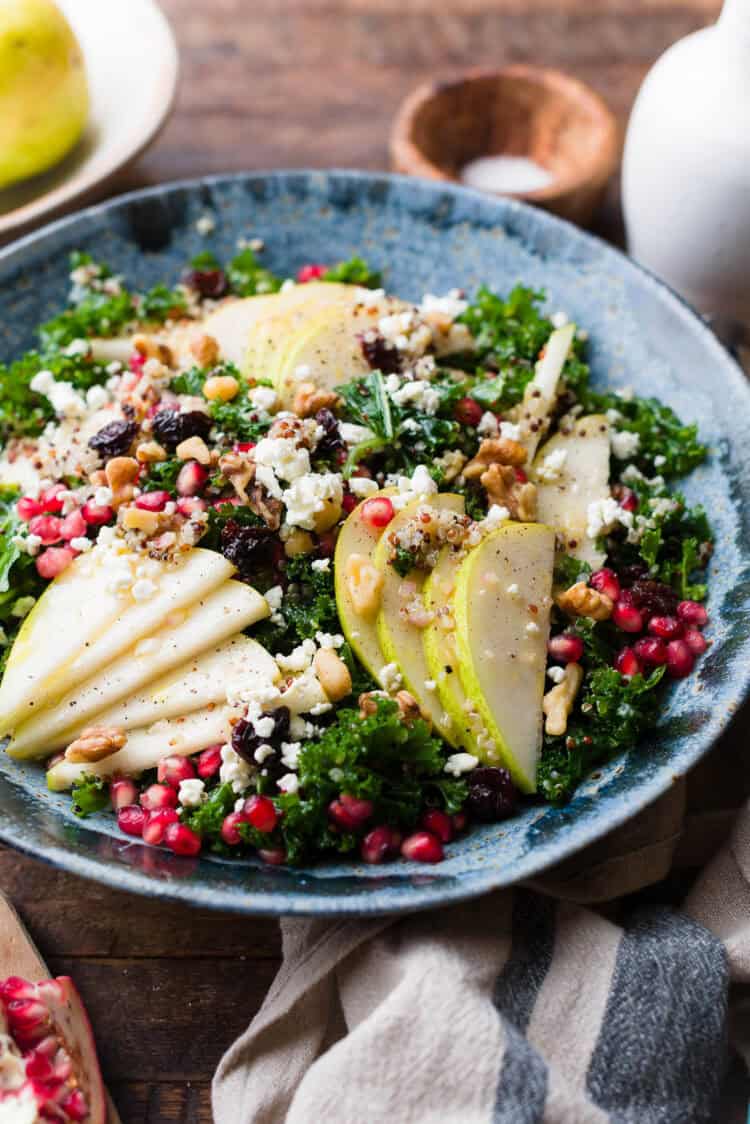 Sliced pears on top of a kale and quinoa salad.