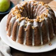 Pear Walnut Bundt Cake with glaze and garnished with walnuts on a serving platter.