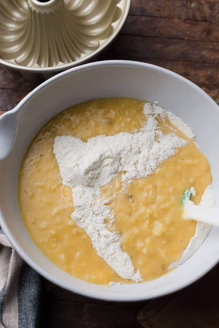Stirring together wet and dry ingredients in a bowl.