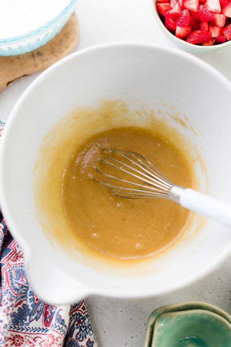 Whisking eggs and sugar in a bowl.