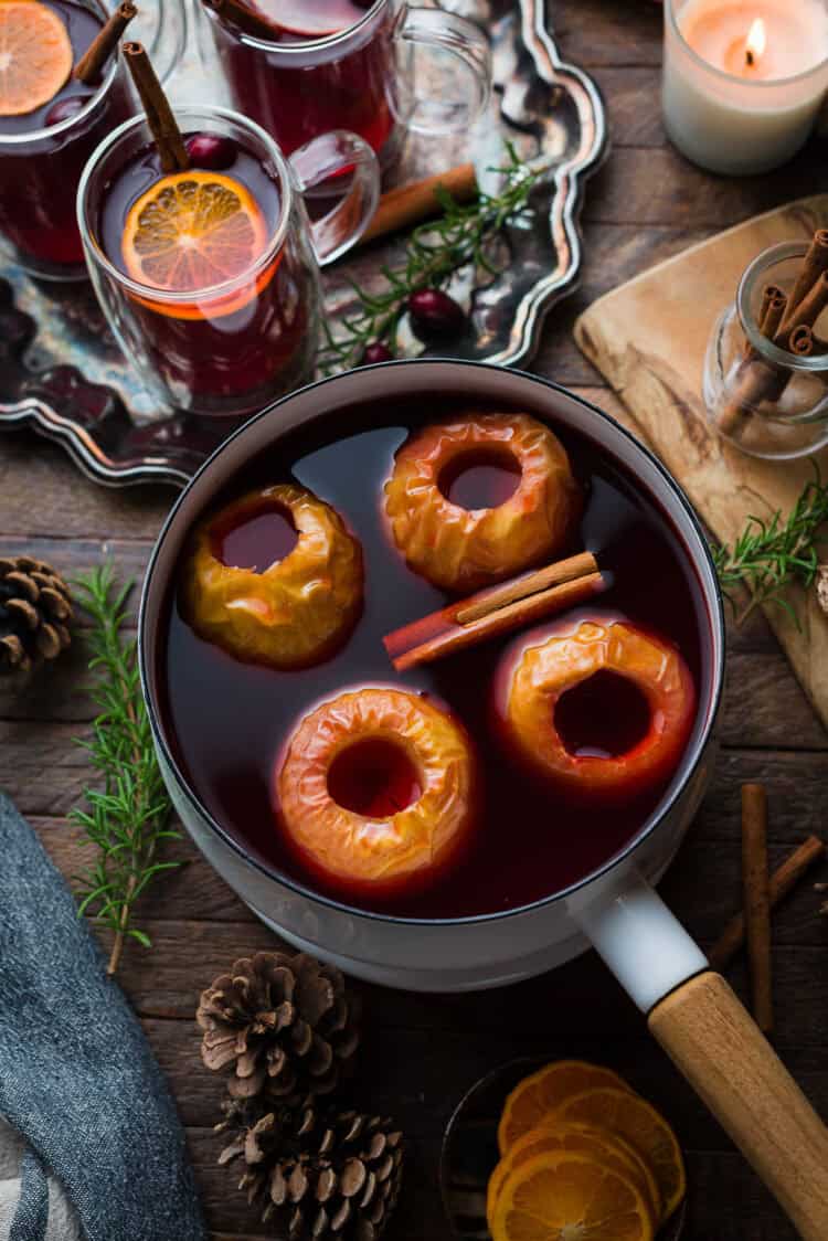 Wassail simmers in a pot with apples and spices.