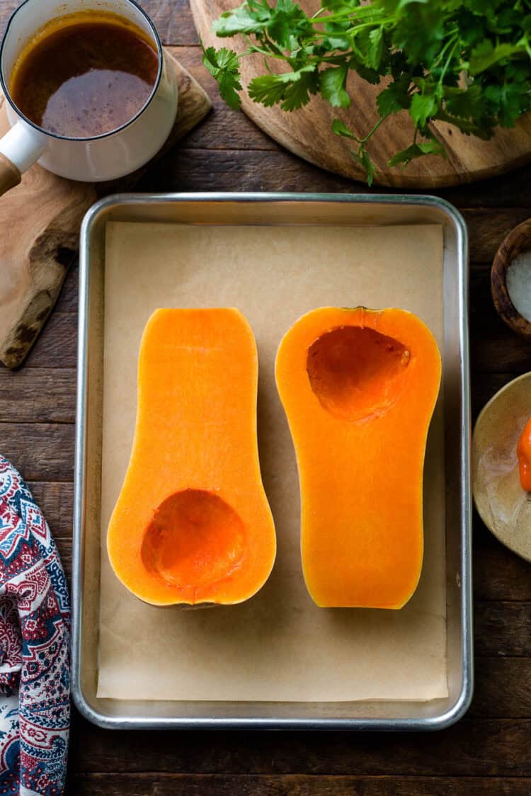 Halved butternut squash on a sheet pan.