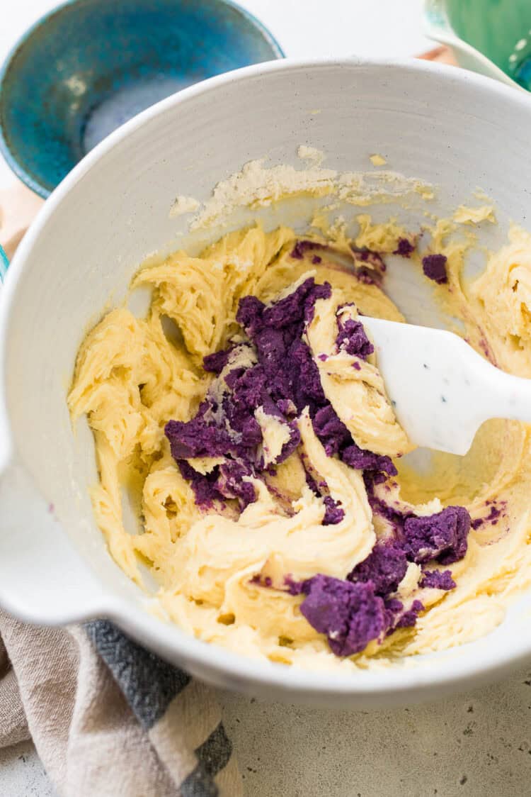 Mixing in mashed ube into ube crinkle cookie recipe.