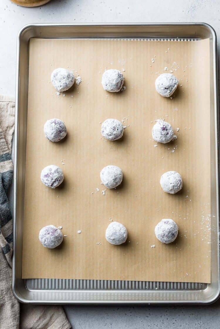 Ube Crinkle cookie dough balls on a baking sheet.