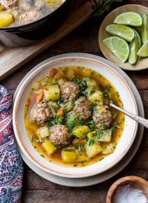Albondigas (Mexican meatball soup) in a bowl: beef meatballs with potatoes, chayote, zucchini, and fresh herbs.