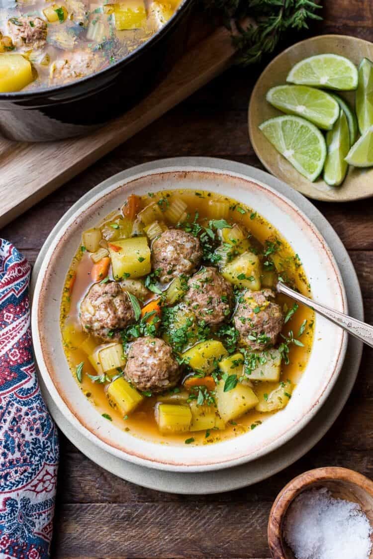 Albondigas (Mexican meatball soup) in a bowl: beef meatballs with potatoes, chayote, zucchini, and fresh herbs.