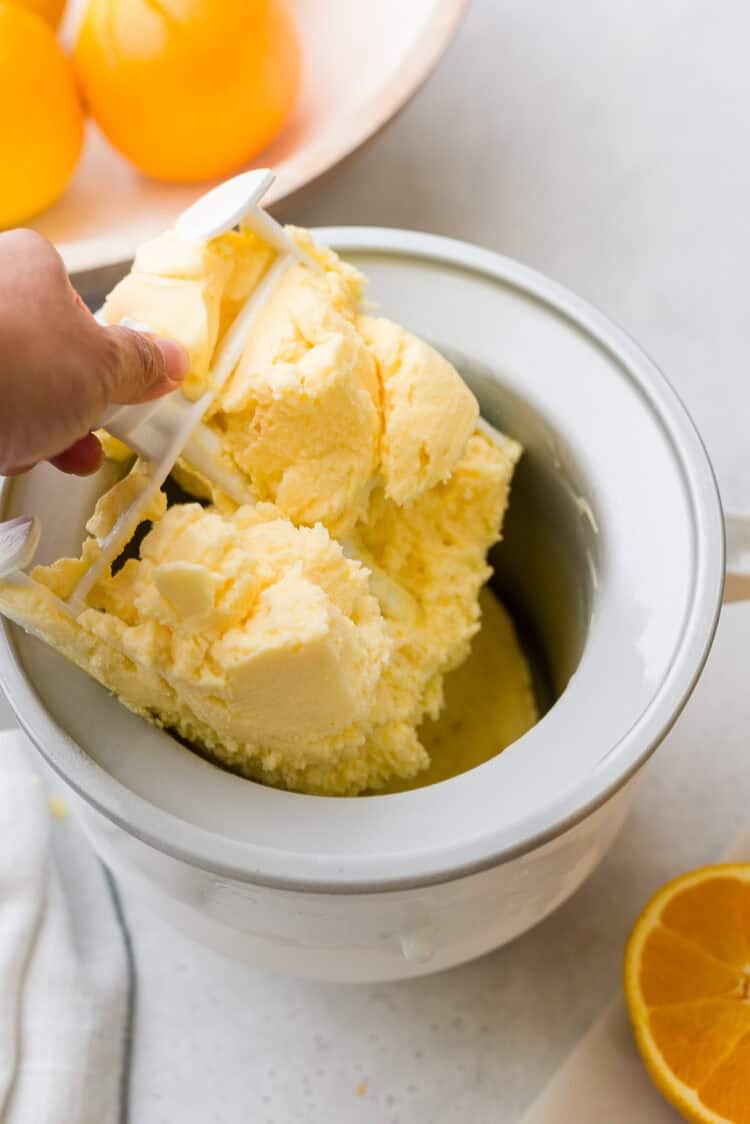 Orange sherbet in an ice cream maker.